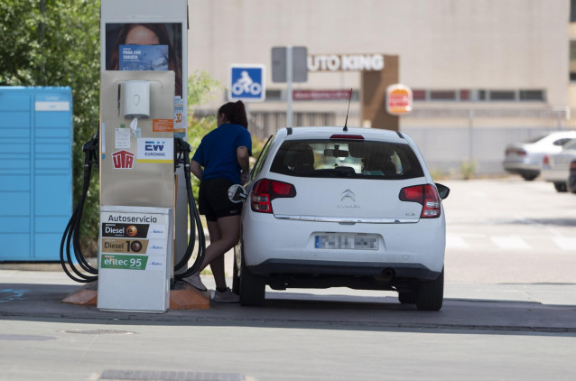 Una mujer reposta en una gasolinera