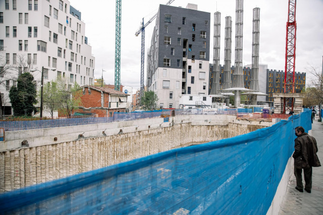 Archivo - Un hombre mira una obra, en construcción
