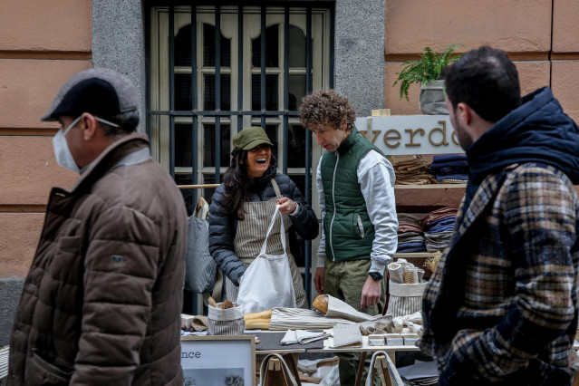 Archivo - Dos dependientes en un puesto en el mercado de las Ranas, en Madrid, en una imagen de archivo.