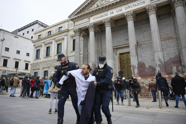 Archivo - Un manifestante es desalojado, en una acción de desobediencia para pedir más ambición en la lucha contra el calentamiento, de La Puerta del Congreso de los Diputados, a 6 de abril de 2022, en Madrid (España).
