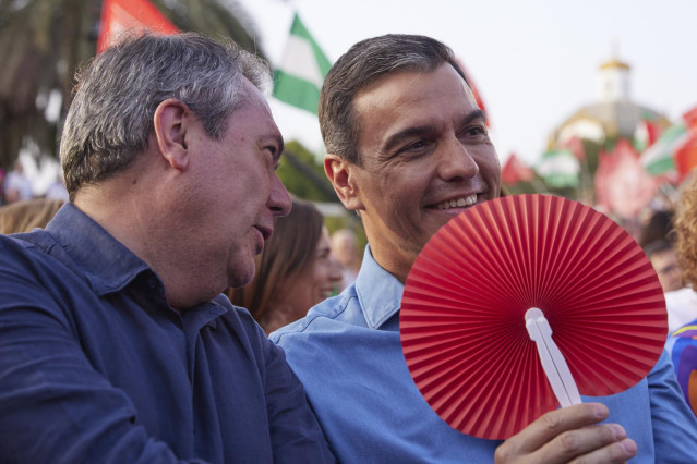 El presidente del Gobierno de España, Pedro Sánchez, (d) con un abanico para combatí el calor, junto al candidato del PSOE a la presidencia de la Junta de Andalucía, Juan Espadas, (i) durante el cierre de campaña del PSOE-A en el Muelle de las Delicias.