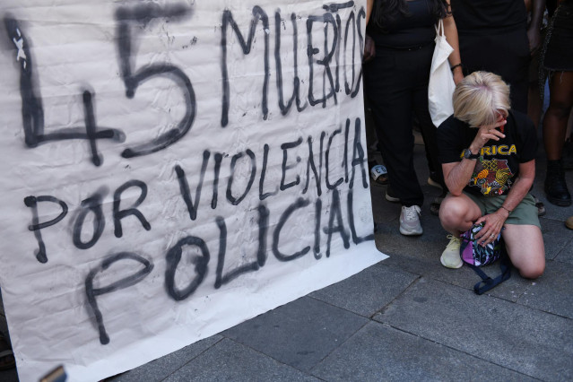 Una mujer junto a una pancarta durante una manifestación contra las políticas migratorias, en la Plaza del Callao, a 26 de junio de 2022, en Madrid (España).