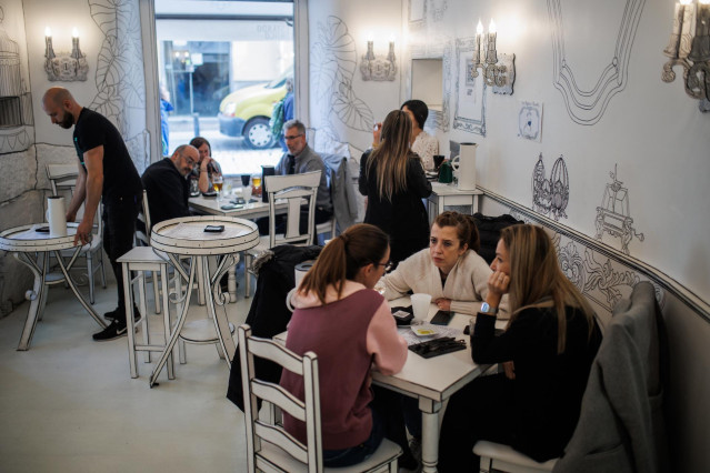 Archivo - Varias personas sentadas en las mesas de un bar