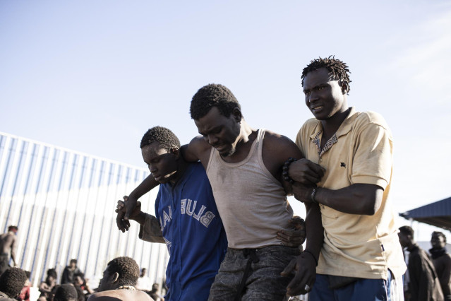 Archivo - Un migrante es ayudado por sus compañeros, tras conseguir saltar la valla de Melilla, a 2 de marzo de 2022, en Melilla (España). (ARCHIVO)