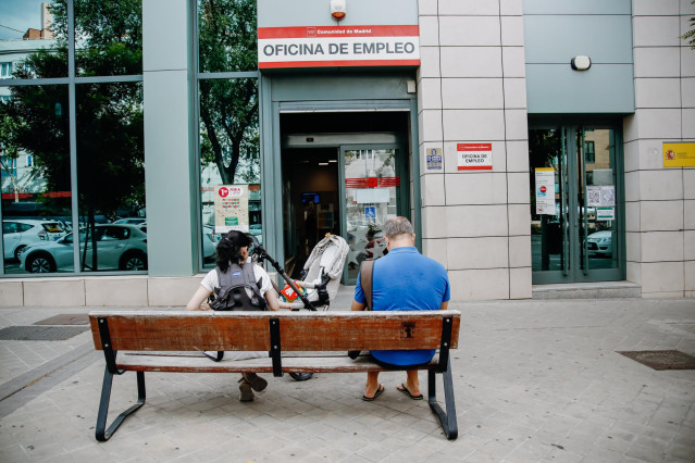 Archivo - Dos personas esperan fuera de una oficina del Servicio Público de Empleo Estatal