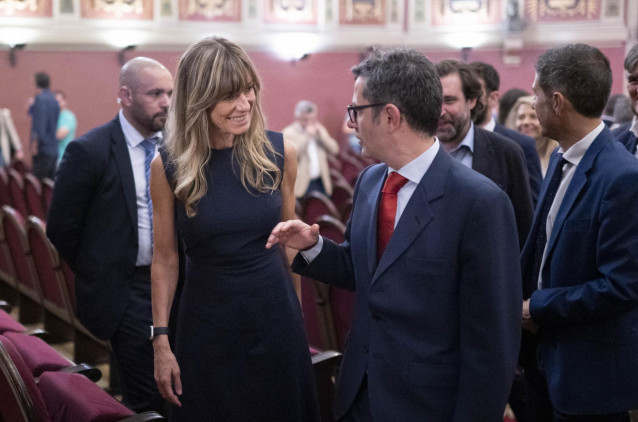 El ministro de la Presidencia, Relaciones con las Cortes y Memoria Democrática, Félix Bolaños, conversa con la mujer del presidente del Gobierno de España, Begoña Gómez, en la presentación del proyecto ‘Los Carteles de la Guerra’, en el Ateneo de Madrid.