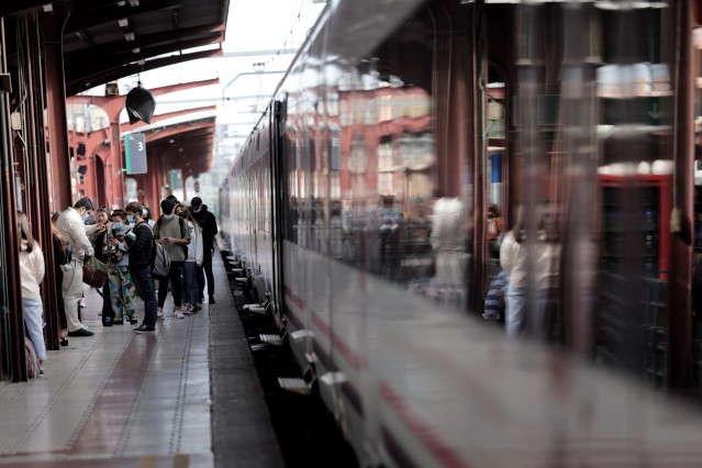 Archivo - Varios pasajeros esperan en uno de los andenes de la estación de Chamartín