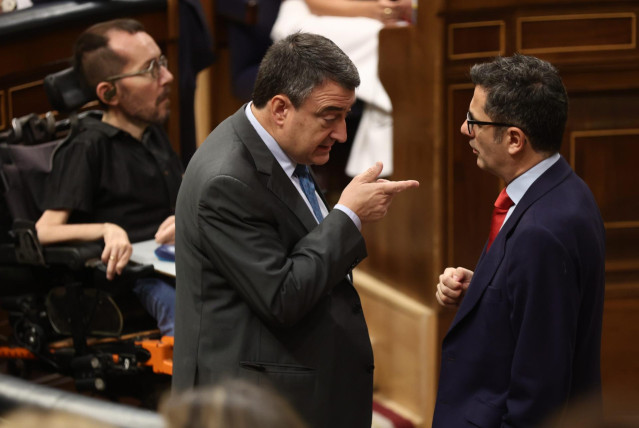 El portavoz del PNV en el Congreso, Aitor Esteban (i), y el ministro de Presidencia, Relaciones con las Cortes y Memoria Democrática, Félix Bolaños, conversan en una sesión de control, en el Congreso de los Diputados, a 22 de junio de 2022, en Madrid (Esp