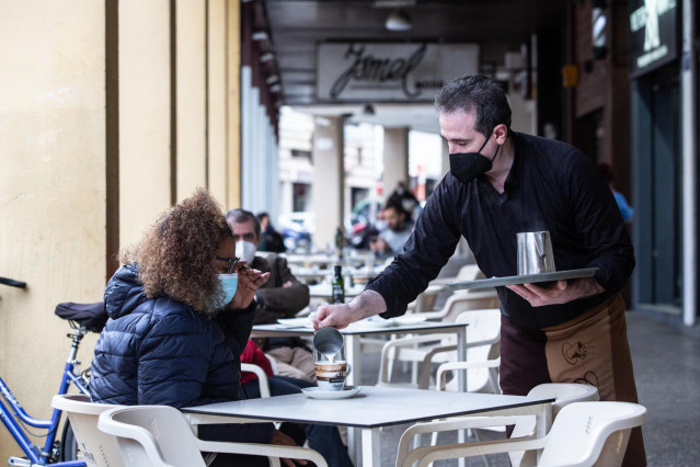 Archivo - Un camarero sirve un café a una clienta en la Cafetería Tristana,