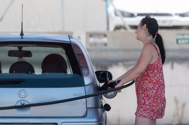 Una pasajera reposta en una gasolinera