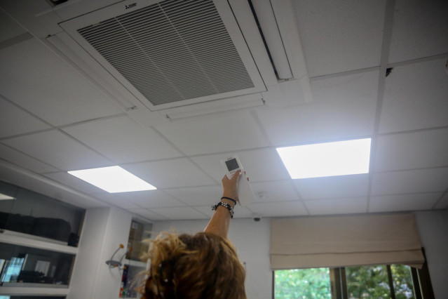 Archivo - Una mujer enciende el aire acondicionado en una oficina, el cuarto día de récord consecutivo en el precio de la luz, a 12 de agosto de 2021, en Madrid (España). El precio medio de la luz en el mercado mayorista vuelve a tocar este jueves nuevos
