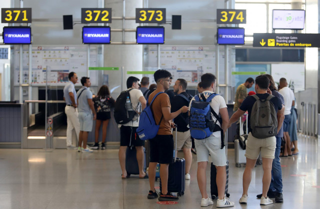 Cientos de turistas hacen colas en los puestos de embarque de Ryanair, en el Aeropuerto Costa del Sol,  Andalucía.