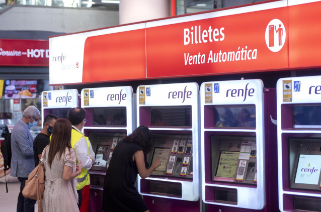 Varios viajeros compran el nuevo abono gratuito en la estación de Atocha