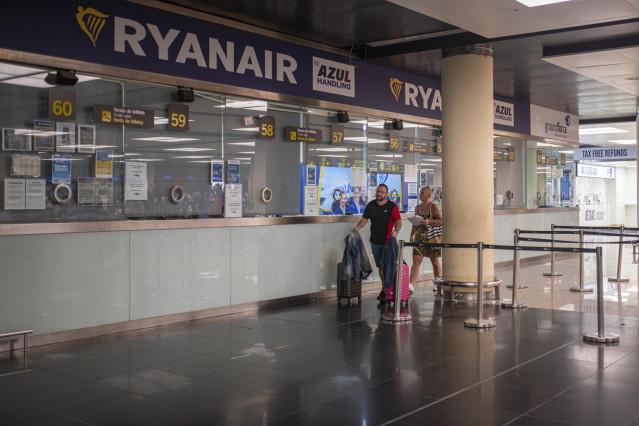 Archivo - Dos personas pasan junto a una ventanilla de Ryanair en el Aeropuerto Josep Tarradellas Barcelona-El Prat, a 8 de agosto de 2022, en Barcelona, Catalunya (España).