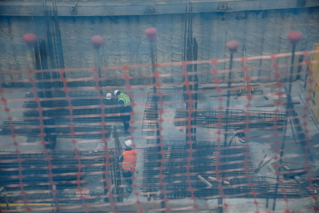 Archivo - Dos obreros trabajando en el forjado de un edificio, en Vallecas