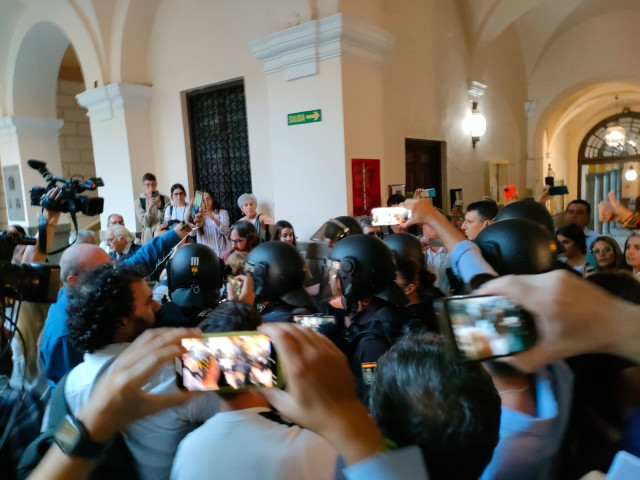 Detractores y simpatizantes de Macarena Olona, a su llegada a la Facultad de Derecho de Granada, rodeada de policías y periodistas