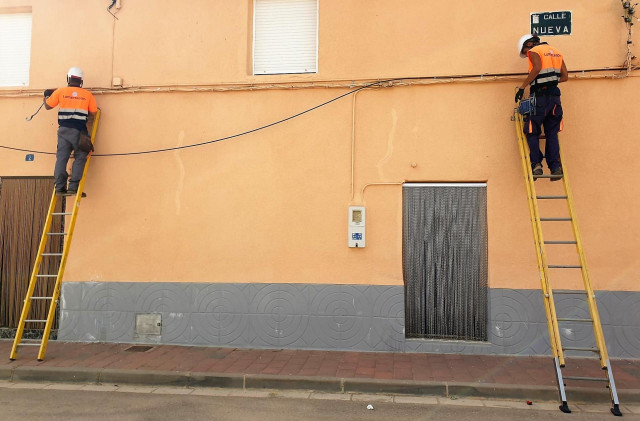 Archivo - Dos operarios instalan fibra óptica