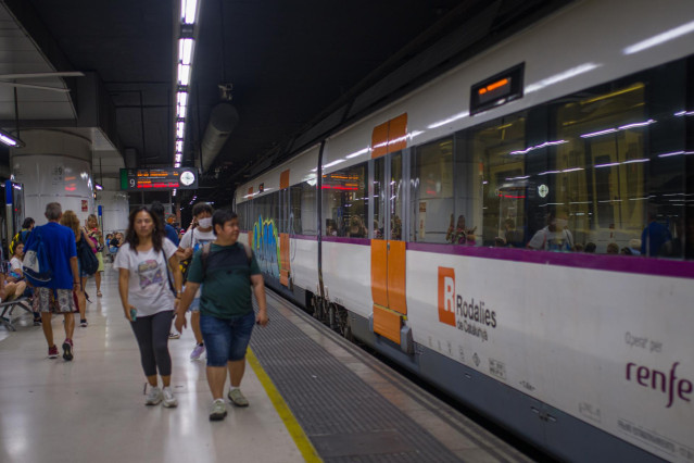 Viajeros al lado de un tren en uno de los andenes de la estación de Sants, a 9 de septiembre de 2022, en Barcelona