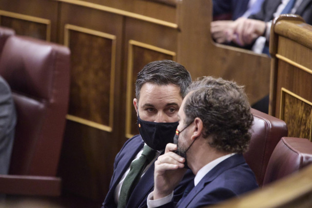Archivo - El líder de Vox, Santiago Abascal (i), y el portavoz parlamentario de Vox, Iván Espinosa de los Monteros, conversan en una sesión plenaria, en el Congreso de los Diputados