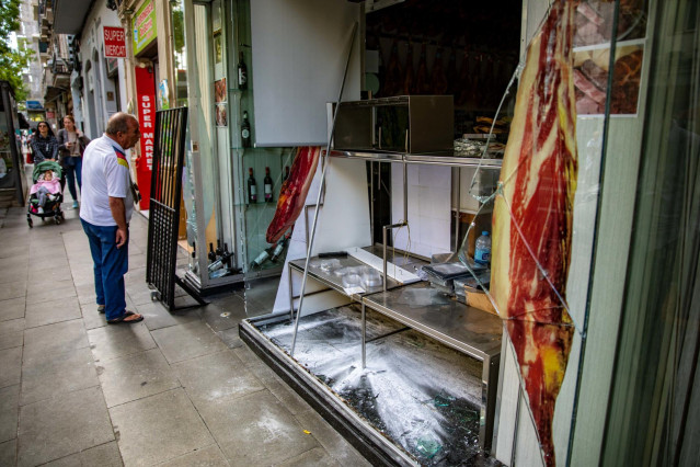 Desperfectos y cristales rotos el escaparate de una charcutería causados por los altercados en las Fiestas de la Mercé