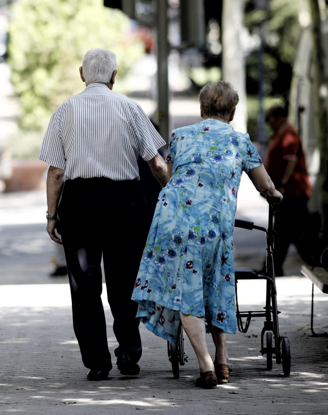 Archivo - Una pareja de pensionistas paseando por un parque de Madrid