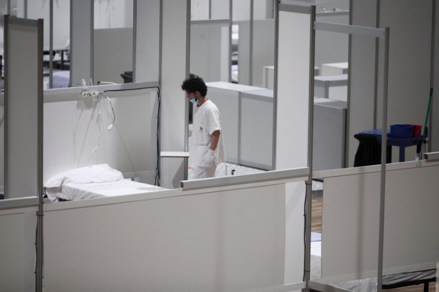 Archivo - Un profesional sanitario frente a una cama vacía en el interior del hospital de campaña de IFEMA durante su último día de funcionamiento por la bajada de la presión asistencial.
