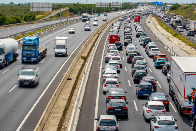 Archivo - Camiones y coches en una carretera