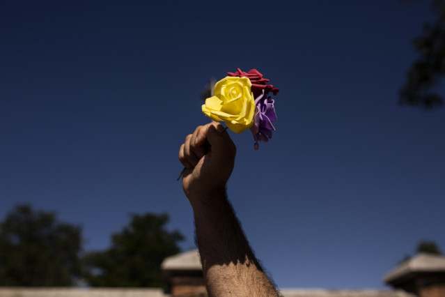Archivo - Un hombre levanta tres rosas de los colores de la bandera republicana durante un homenaje a las 13 Rosas y los 43 Claveles en el 82º aniversario de su fusilamiento, en el Cementerio de la Almudena, a 5 de agosto de 2021, en Madrid (España). Foto