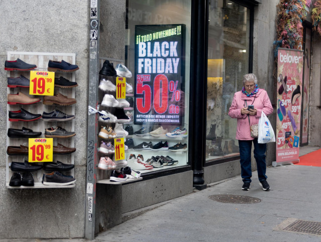 Una mujer pasa por delante de una tienda que anuncia un cartel publicitario del ‘Black Friday’
