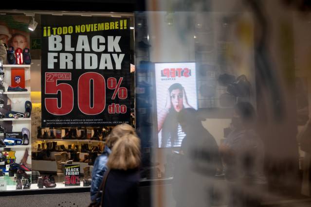 Una persona pasa por delante de una tienda que anuncia un cartel publicitario del ‘Black Friday’