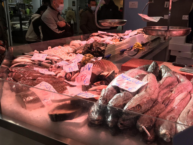 Archivo - Un puesto de pescados en un mercado con clientes