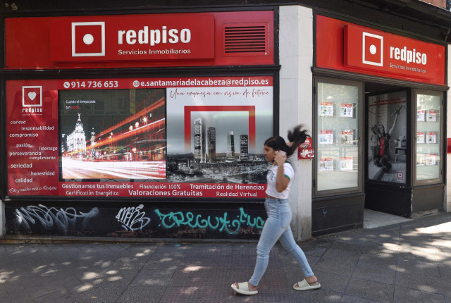 Archivo - Una mujer pasa por una oficina de redpiso, a 1 de septiembre de 2022, en Madrid