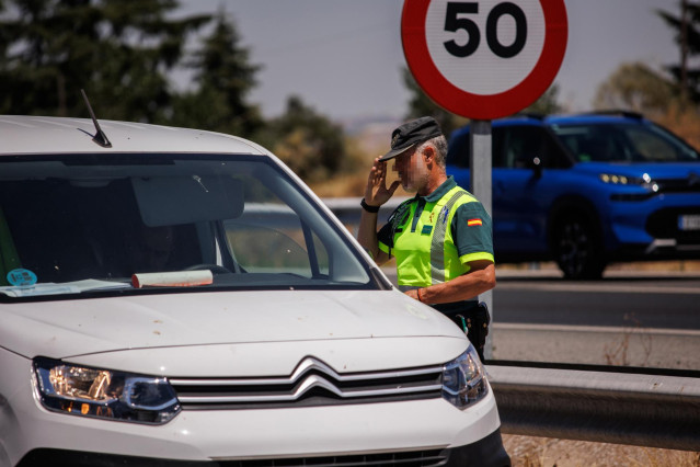 Archivo - Un agente de la Guardia Civil para a un vehículo durante un control