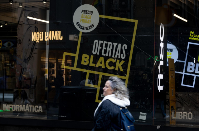 Una persona pasa por delante de una tienda que anuncia un cartel publicitario del ‘Black Friday’,