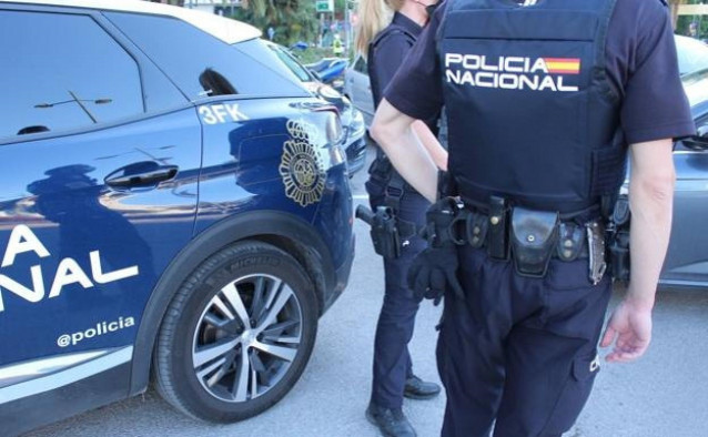Agenes de la Policía Nacional junto a un coche