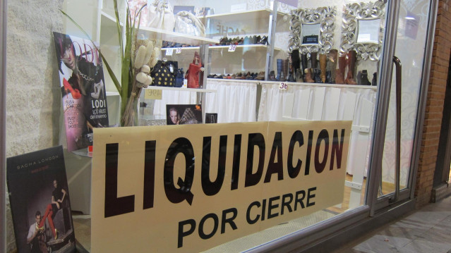 Archivo - Un comercio anunciando la liquidación de sus productos por cierre