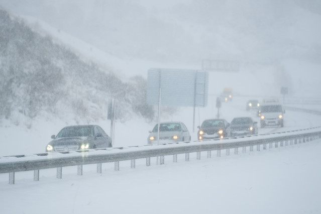 Varios coches conducen por una carretera cubierta de nieve, a 18 de enero de 2023, en Cantabria