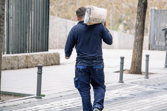 Archivo - Un hombre pasa junto a una obra, en el centro de Madrid