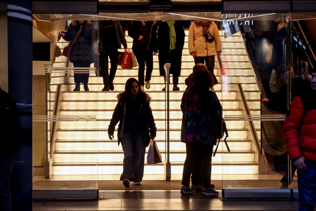 Varias personas entran y salen de un establecimiento comercial el primer día de las rebajas de enero