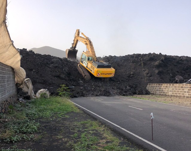 Archivo - Una pala mecánica procede a la retirada de la lava para la habilitación de un camino para el paso de los especialistas en mediciones geotécnicas del nuevo terreno creado por las coladas volcánicas