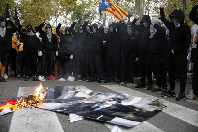 Archivo - Varios encapuchados queman una foto de Pedro Sánchez y Pere Aragoés durante la manifestación organizada por la Izquierda Independentista, con motivo de la Diada