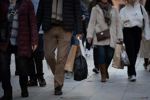 Archivo - Varias personas realizan sus compras navideñas en la avenida de la Puerta del Ángel.