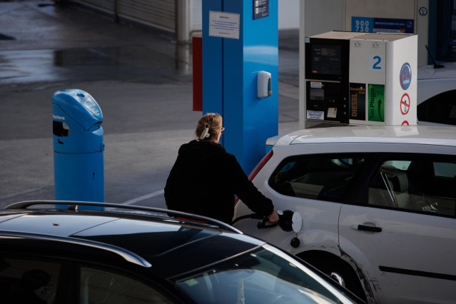 Archivo - Una mujer reposta combustible en una gasolinera, a 2 de diciembre de 2022, en Madrid (España).