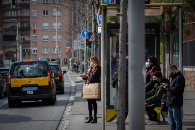 Archivo - Varios taxis pasan junto a una parada, donde varias personas esperan el autobús, durante la huelga de autobuses en Mitre Ganduxer, a 17 de febrero de 2022, en Barcelona, Cataluña, (España). Los sindicatos CCOO, UGT, ACTUB, SIT, CGT y ACAT han co