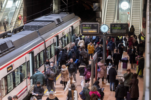Varias personas esperan en el andén de Cercanías, en la estación Puerta de Atocha-Almudena Grandes.