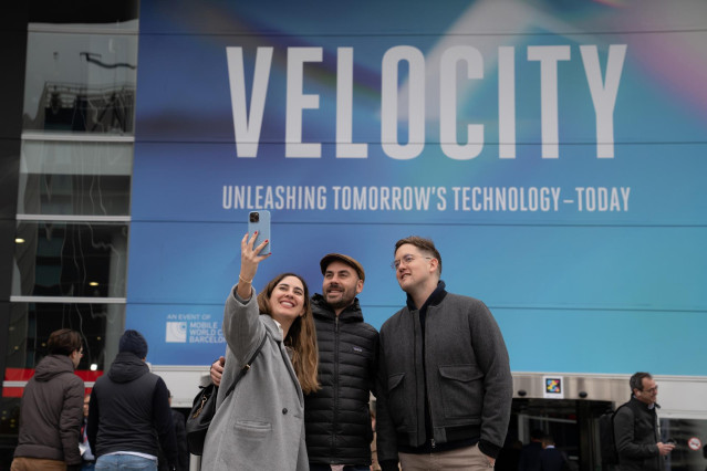 Tres personas se hacen un selfie en una de las entradas del Mobile World Congress (MWC) 2023, a 28 de febrero de 2023, en L'Hospitalet de Llobregat, Barcelona, Catalunya (España). El Mobile de esta edición, donde exponen sus productos y servicios más de 2
