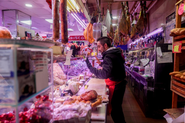 Archivo - Un charcutero atiende en la tienda de comestibles ‘Los Mares Alimentación’, en el barrio de Prosperidad, a 24 de diciembre de 2022, en una imagen de archivo.