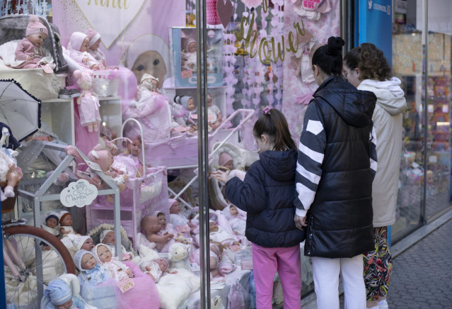 Archivo - Varias personas miran el escaparate de una tienda de juguetes. A 27 de diciembre de 2022, en Sevilla (Andalucía, España).