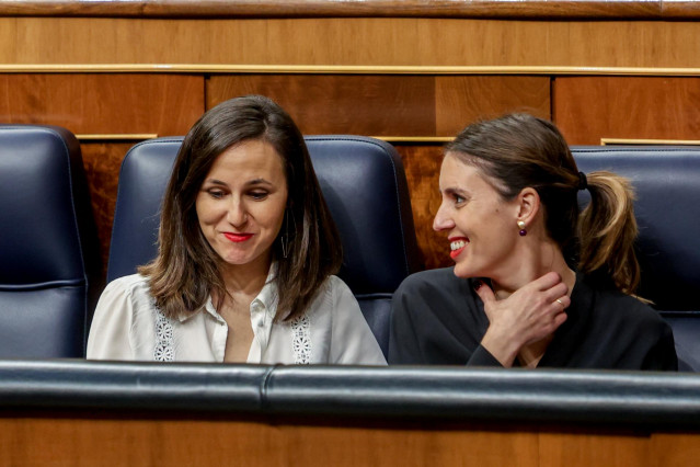 La ministra de Derechos Sociales y Agenda 2030, Ione Belarra (i), y la ministra de Igualdad, Irene Montero (d), conversan durante una sesión plenaria en el Congreso de los Diputados, a 7 de marzo de 2023, en Madrid (España).
