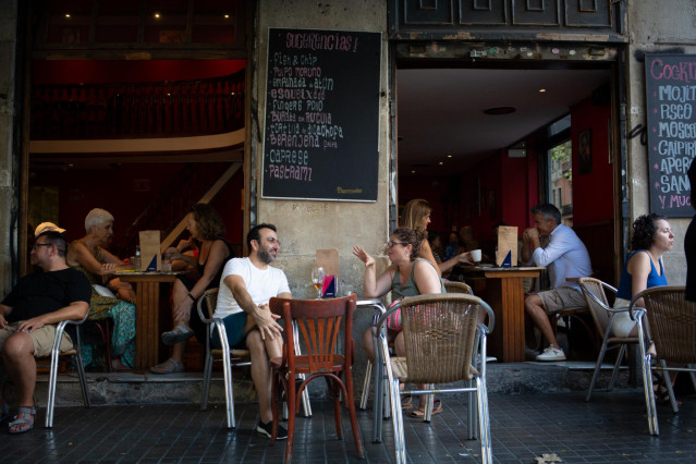 Archivo - Varias personas sentadas en terrazas en la plaza dels Àngels del Raval